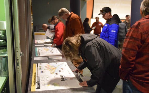 Community members examine illustrations of the three proposed growth plans created by the comprehensive plan rewrite project team during a community work session on Tuesday, Oct. 22, 2024, at the Alaska Maritime National Wildlife Refuge Visitor Center in Homer, Alaska. (Delcenia Cosman/Homer News)