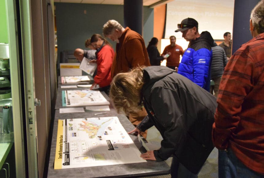 <p>Community members examine illustrations of the three proposed growth plans created by the comprehensive plan rewrite project team during a community work session on Tuesday, Oct. 22, 2024, at the Alaska Maritime National Wildlife Refuge Visitor Center in Homer, Alaska. (Delcenia Cosman/Homer News)</p>