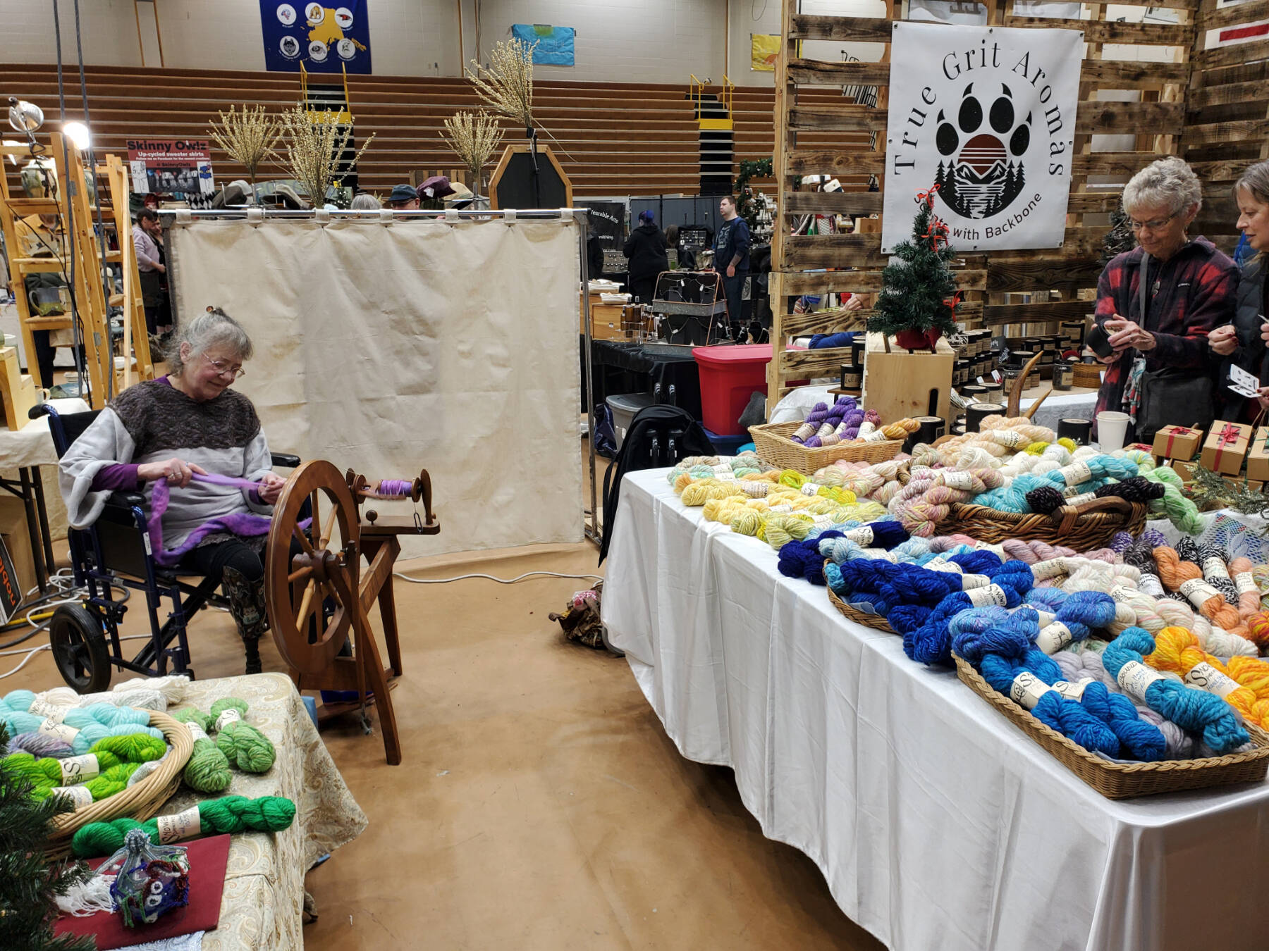 A vendor spins hand-dyed yarn at her booth at Homer Council on the Arts’ annual Nutcracker Faire on Saturday, Dec. 7, 2024, in the Homer High School gym in Homer, Alaska. (Delcenia Cosman/Homer News)