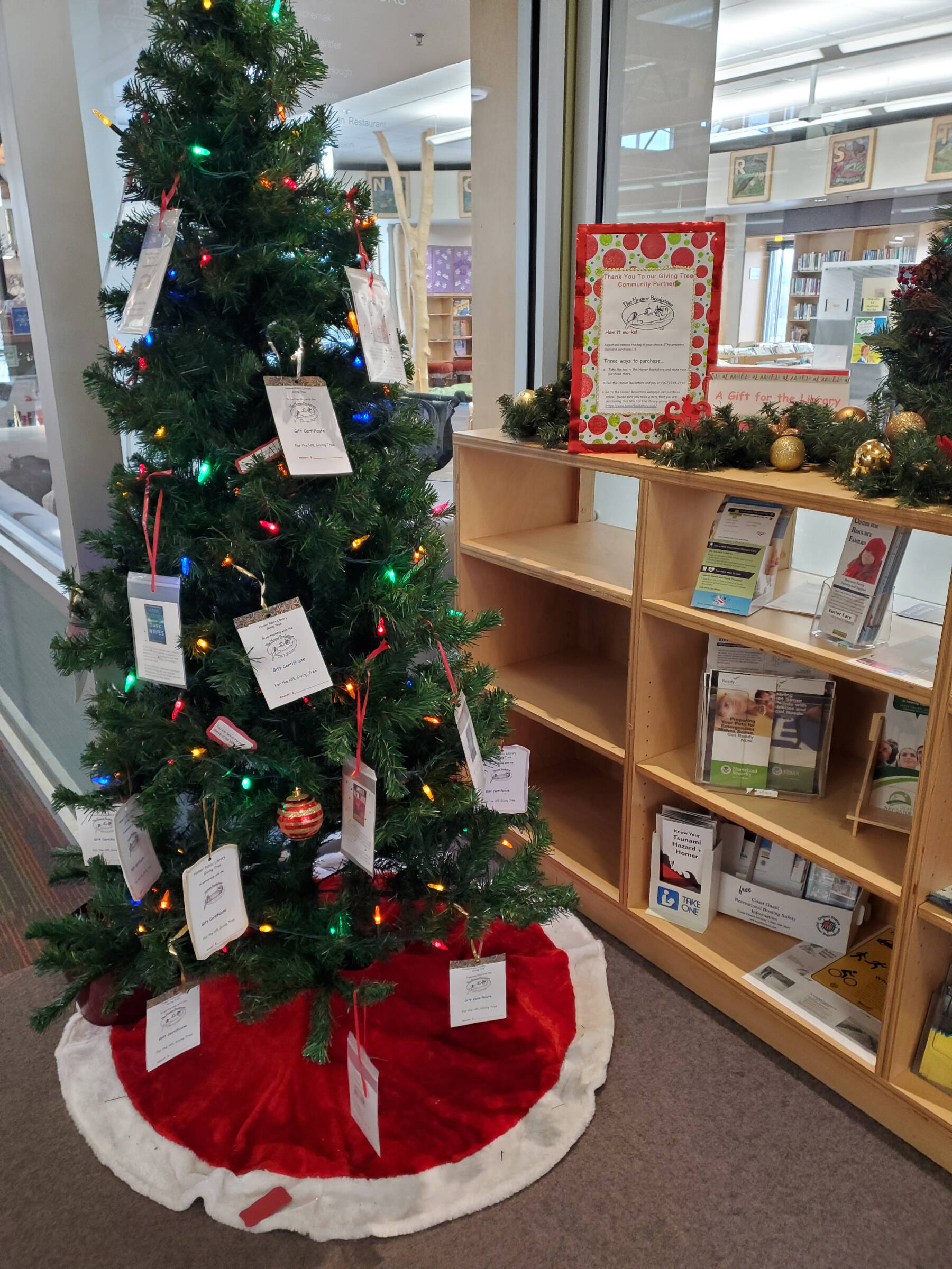 The Book Giving Tree, hosted by the Friends of the Homer Library and the Homer Bookstore, is on display in the Homer Public Library on Saturday, Dec. 14, 2024, in Homer, Alaska. (Delcenia Cosman/Homer News)