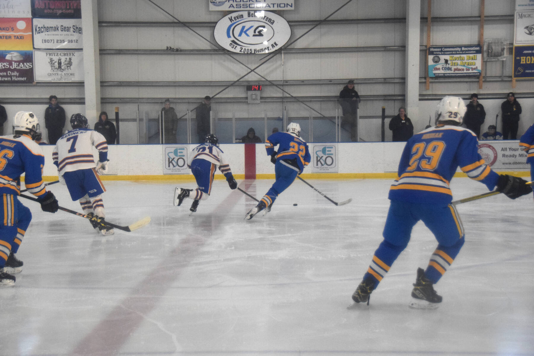 Homer’s Clyde Clemens (21) battles a Kodiak Bears player for the puck during the varsity home game on Saturday, Dec. 14, 2024, at Kevin Bell Arena in Homer, Alaska. (Delcenia Cosman/Homer News)