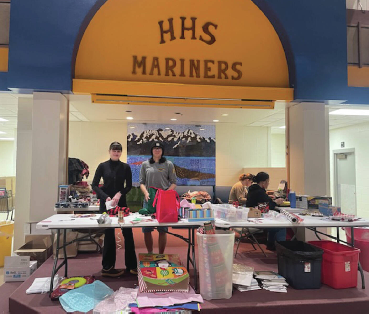 Ella Gustafson, Mariner junior, and Mally Im, senior, wrap presents at the Share the Spirit presentation in the Homer High School Commons on Saturday. Emilie Springer/ Homer News