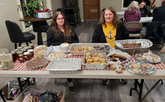 Laurie Rudy (right), board treasurer for the Anchor Point Food Pantry, and Rebecca Rudy (left) host the first night of a two-day bake sale fundraiser for the Anchor Point Food Pantry held at the Virl “Pa” Haga VFW Post 10221 on Friday, Dec. 20, 2024, in Anchor Point, Alaska. Items for sale during the fundraiser were made and donated by members of the community. (Delcenia Cosman/Homer News)