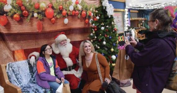 Parents and kids pose for photos with Santa at the Procrastinators Fair on Saturday, Dec. 21<ins>, 2024,</ins> at Christian Community Church in Homer<ins>, Alaska</ins>. (Delcenia Cosman/Homer News)