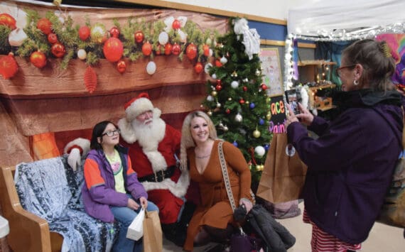 Parents and kids pose for photos with Santa at the Procrastinators Fair on Saturday, Dec. 21<ins>, 2024,</ins> at Christian Community Church in Homer<ins>, Alaska</ins>. (Delcenia Cosman/Homer News)