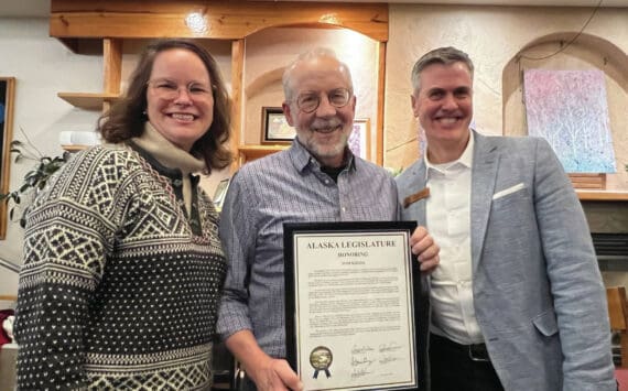 Alaska Representatives Sarah Vance from Homer and Andrew Gray from Anchorage present Tom Kizzia with a state legislative citation award at the Homer Public Library on Tuesday, Dec. 17.  Photo provided by Cheryl Illg with Friends of the Homer Public Library.