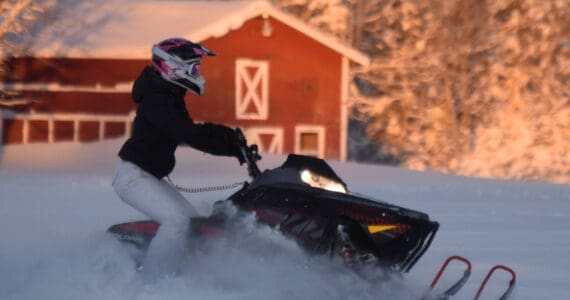 A snowmachine rider takes advantage of 2 feet of fresh snow on a field down Murwood Avenue in Soldotna, Alaska, on Monday, Dec. 12, 2022. (Jake Dye/Peninsula Clarion)