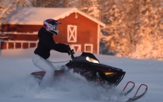 A snowmachine rider takes advantage of 2 feet of fresh snow on a field down Murwood Avenue in Soldotna, Alaska, on Monday, Dec. 12, 2022. (Jake Dye/Peninsula Clarion)