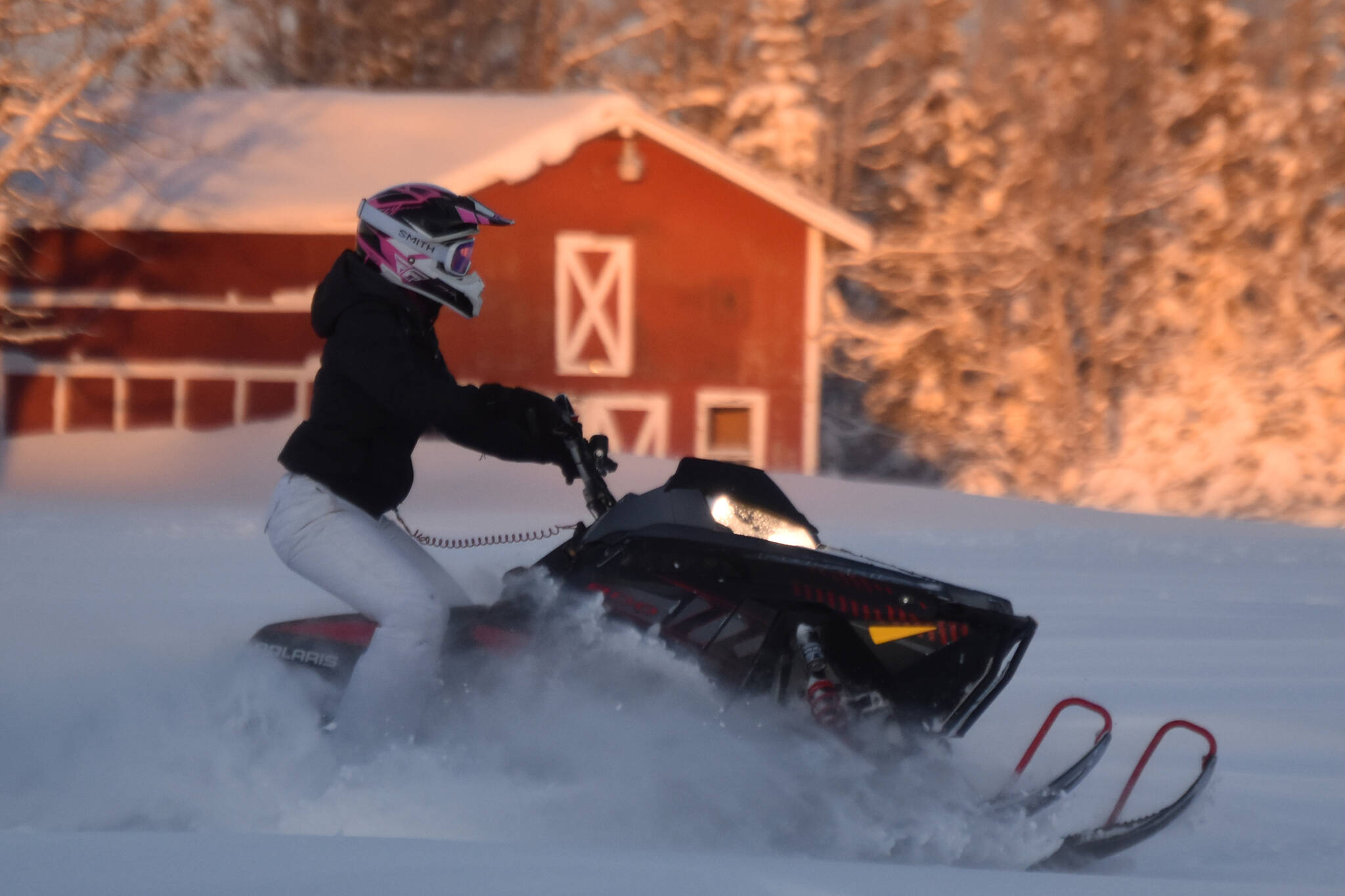 A snowmachine rider takes advantage of 2 feet of fresh snow on a field down Murwood Avenue in Soldotna, Alaska, on Monday, Dec. 12, 2022. (Jake Dye/Peninsula Clarion)