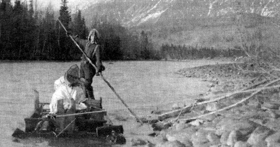 Keith McCullagh is photographed poling a raft down the Kenai River in 1911 during a forest survey. (U.S. Forestry Department photo by John “Jack” Brown)