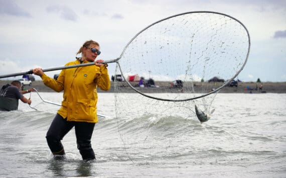 Alexis Alamillo, of Anchorage, carries a sockeye salmon caught in a dipnet from the mouth of the Kenai River in Kenai, Alaska, on Wednesday, July 17, 2024. (Jake Dye/Peninsula Clarion)