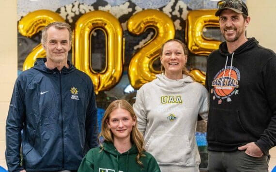 Homer senior Gracie Miotke (seated) committed to run track and field at the University of Alaska Anchorage on Wednesday, March 5, 2025, at Homer High School in Homer, Alaska. Behind Miotke are Homer head coach Bob Ostrom, mother, Amanda Miotke, and father, Dan Miotke. (Photo provided)