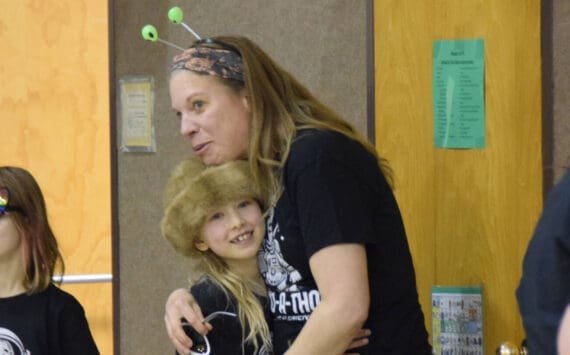 Teacher Jennifer Reinhart hugs Runa Larson as students file into the gymnasium before the Read-a-thon event on Feb. 28, 2025 at Paul Banks Elementary School in Homer, Alaska. (Chloe Pleznac/Homer News)